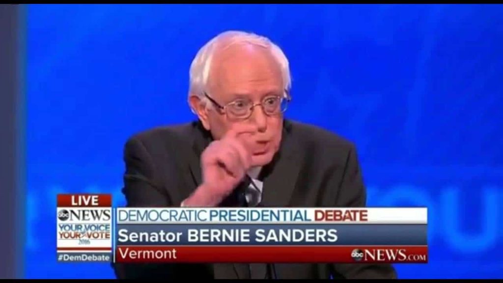 هيلاري كلينتون خلال مناظرة على الهواء مع منافسيها داخل الحزب الديمقراطي بيرني ساندرز ومارتن أومالي