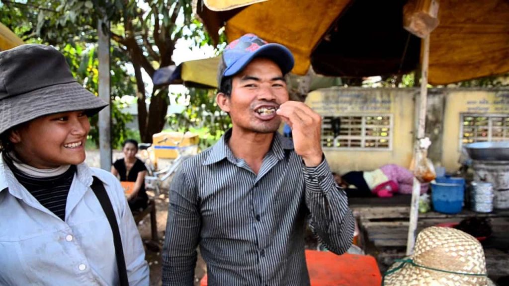 قلي العناكب، وإضافة بعض الأعشاب إليها، وتناولها