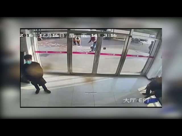 المارة يتكاتفون لجمع أموال رجل طارت بها الرياح أمام بنك في مدينة داليان بالصين تطايرت أمواله أمام البنك