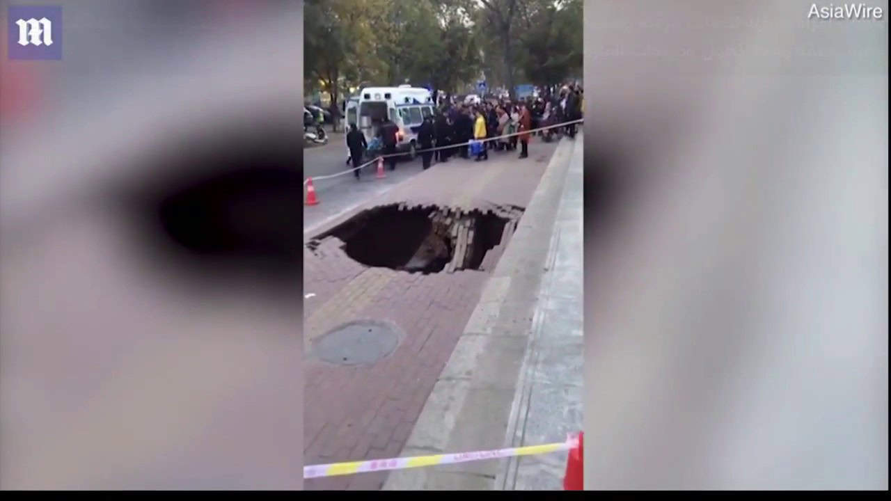 انشقاق الأرض في أحد الشوارع الصينية يبتلع امرأة وسط ذهول المارة ومحاولات إنقاذها الأرض تنشقّ وتبتلع امرأة