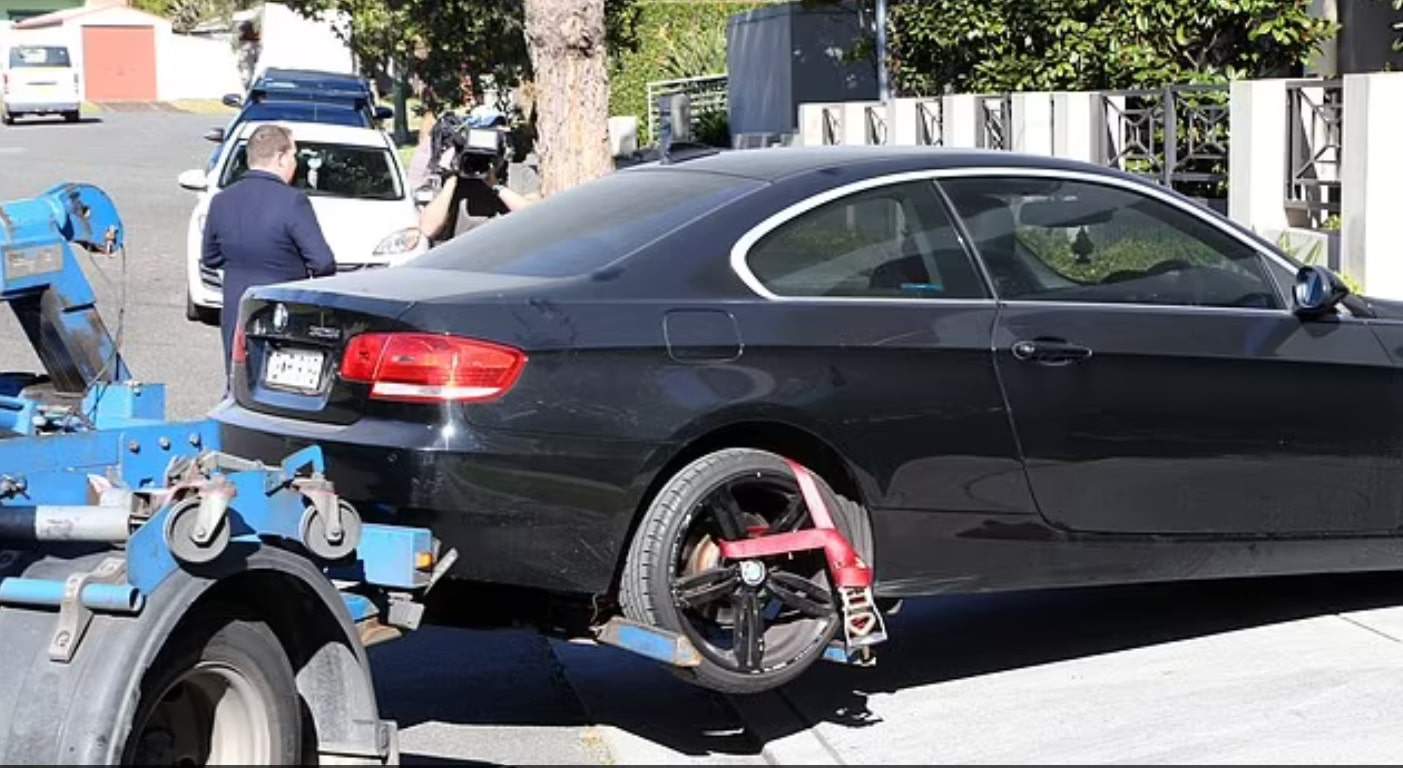 تم إزالة سيارة BMW سوداء مغطاة بالغبار من مرآب المبنى السكني