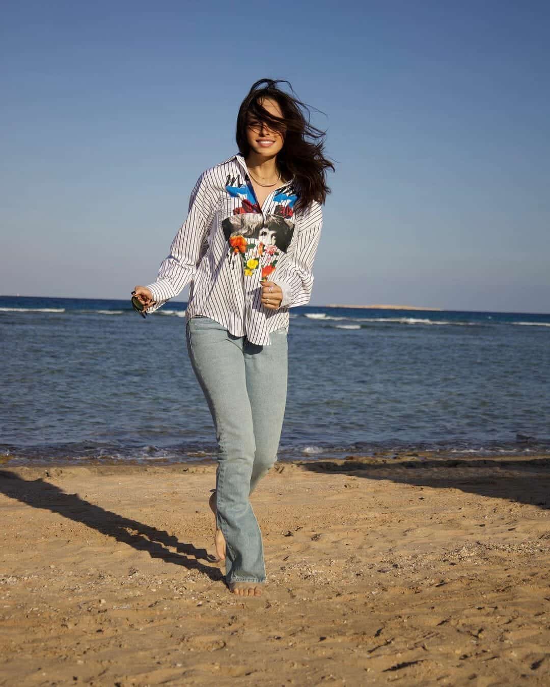 آمال ماهر على الشاطئ بملابس صيفية وحافية القدمين