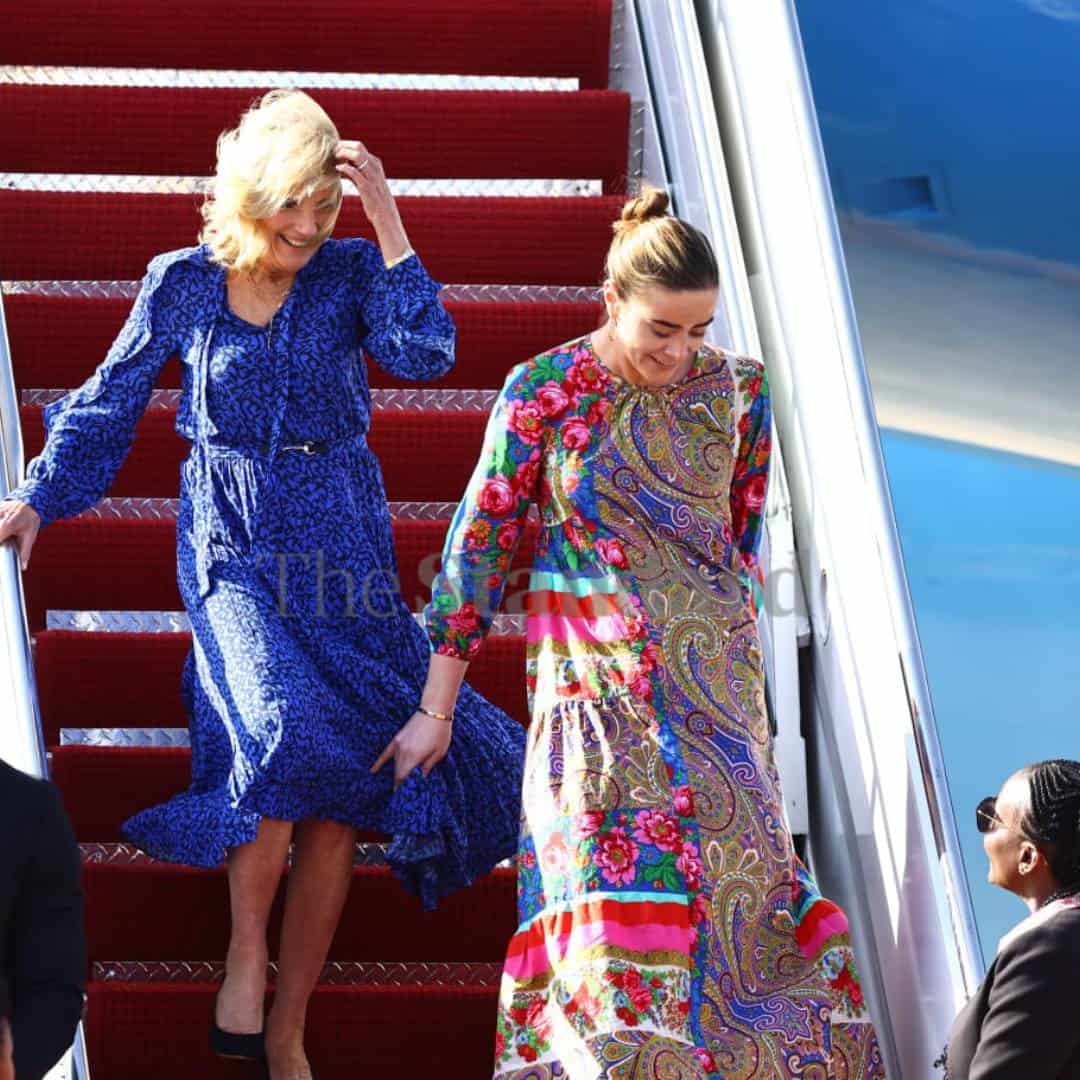 نعومي بايدن تمسك بفستان جيل بايدن خلال نزولهما من الطائرة