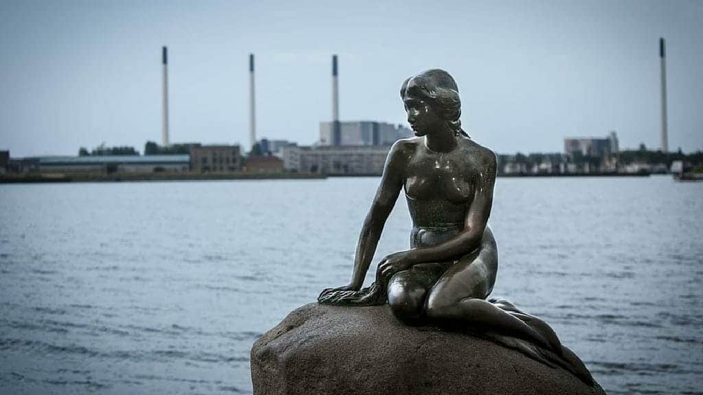 تمثال حورية البحر الصغيرة  التي تجلس على صخرة في مرفأ كوبنهاغن بالدنمارك