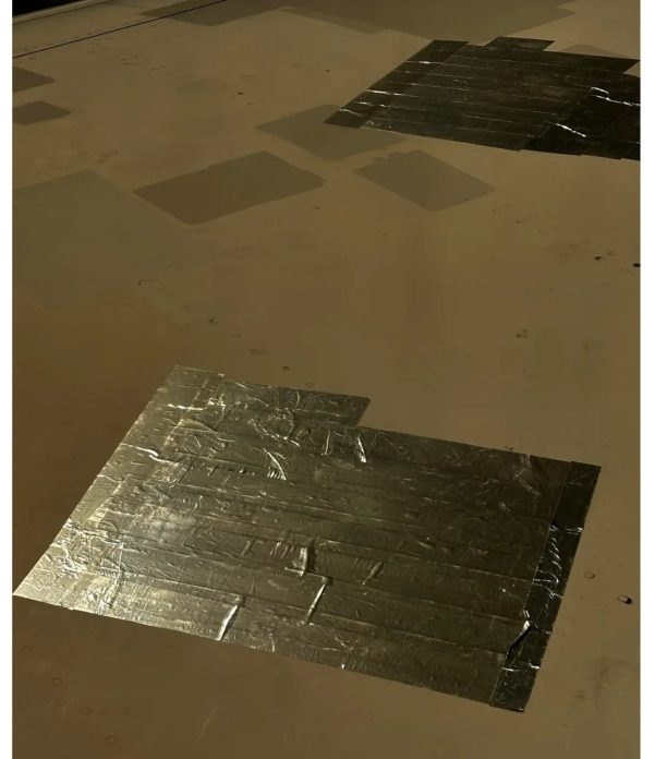 شريط لاصق يغطي ثقوبًا على جناح الطائرة