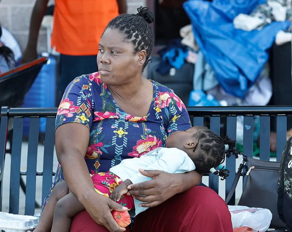 امرأة مشردة تحتضن طفلاً في ولاية ماساتشوستس، حيث أكثر من نصف الأشخاص الذين يعيشون في ملاجئ العائلات هم من المهاجرين،