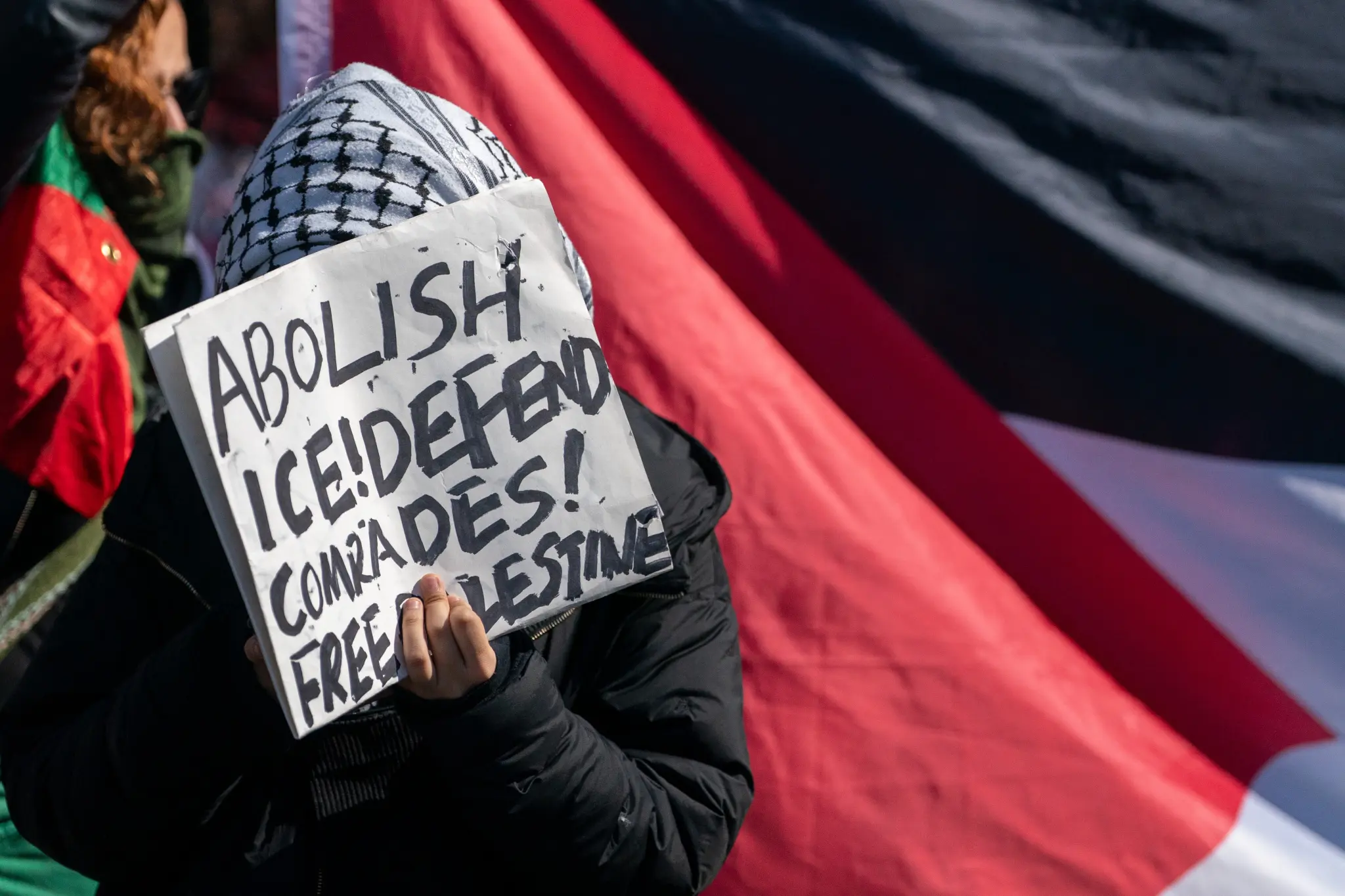 متظاهر يحمل لافتة تطالب بإلغاء ICE.
